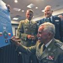 Polish army Gen. Mieczyslaw Bieniek, foreground, signs a commemorative poster during a memorandum of understanding (MOU) signing ceremony at Headquarters Supreme Allied Commander Transformation in Norfolk, Va 130828-N-SO729-033